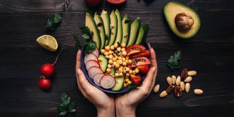 Hands holding healthy salad with chickpea and vegetables. 