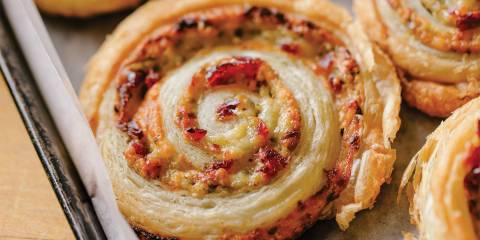 Cheesy Pesto Wheels A pinwheel pastry on a baking sheet