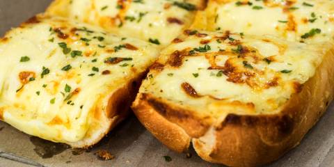 fresh cheesy garlic bread on a baking sheet