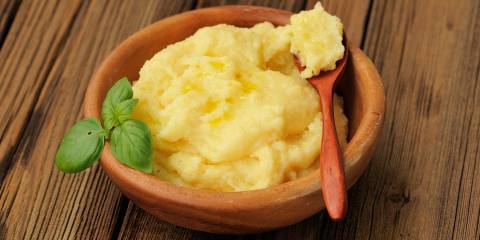 Oven-Baked Polenta with Fresh Herbs a bowl of cheesy polenta with basil