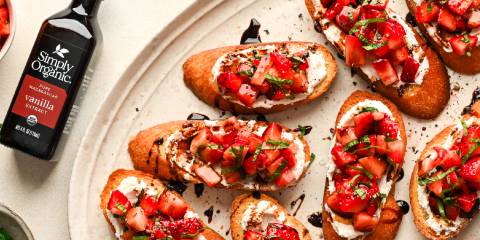 a plate of bruschetta with strawberries, goat cheese, and balsamic