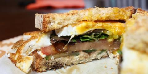 an egg sandwich with goat cheese, spinach, and cucumber