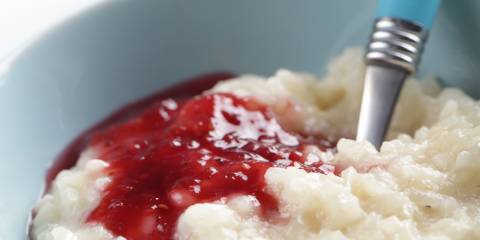 Ginger Rice Pudding a bowl of rice pudding drizzled with a berry sauce