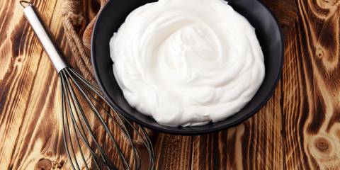 Homemade Whipped Cream Homemade Whipped Cream in a black bowl with a whisk on a wooden table.