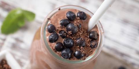 a dish of creamy chocolate mousse topped with berries and seeds