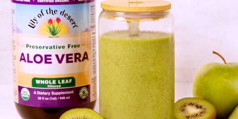 a green smoothie next to a bottle of whole leaf aloe vera