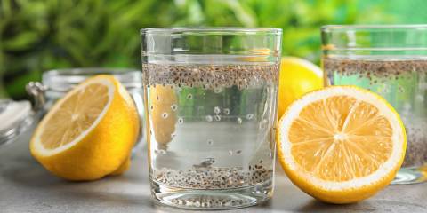 Gluten-Free Lemon Chia Fresca  chia soaking in a glass of water with sliced lemons