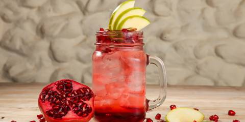 Pear-Pomegranate Mocktail a glass of pomegranate mocktail garnished with pear slices