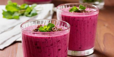 cups of berry yogurt smoothies with mint garnish
