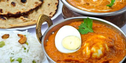 a boiled and sauteed egg in red curry with roti
