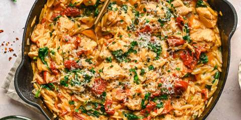 One-Pan Tuscan Chicken Orzo a pan of seasoned chicken with orzo and spinach