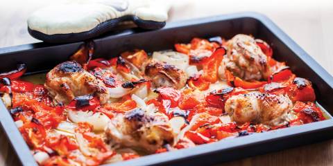 Ratatouille Sheet Pan Chicken just pulled out of the oven next to oven mitt.