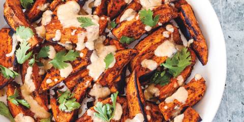 Roast Sweet Potatoes with Tahini Dressing sweet potatoes plated with tahini and cilantro