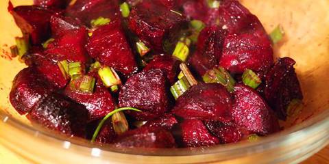 roasted beets mixed with scallions in a bowl
