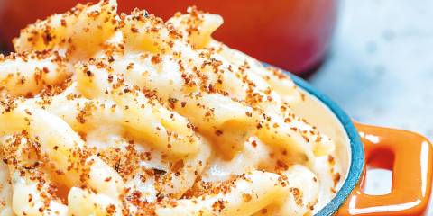 Smoky mac and cheese served in an orange mini dutch oven.