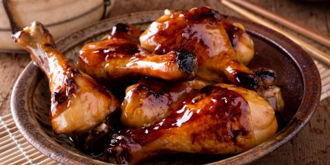 Sticky Chicken Drumsticks Sticky chicken on a plate ready sprinkle with scallions and serve.