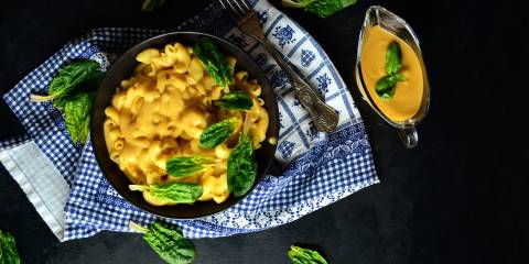 a bowl of vegan mac and cheese with extra cashew cheese on the side