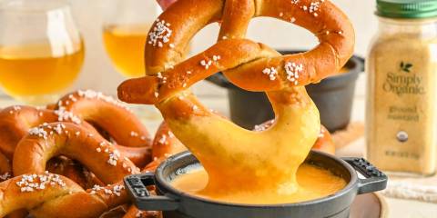 Beer Cheese Dip a soft pretzel being dipped in beer cheese