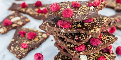Crispy Chocolate Bark A stack of chocolate bark with raspberries and crispy almond and grain flakes