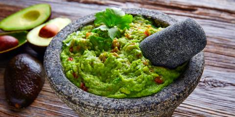 Guacamole guacamole sauce served in a traditional stone bowl
