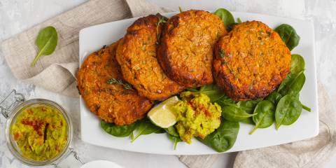 Sweet Potato and Mustard Turkey Burgers Sweet Potato and Mustard Turkey Burgers on a white platter on a bed of spinach greens.