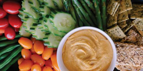 Sweet Potato & Cashew Dip Sweet Potato Cashew Dip on a platter with veggies and crackers.