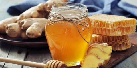 a jar of honey and fresh sliced ginger root