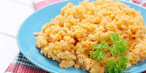Cooked red lentils on a light blue plate.