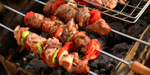 shish kebabs and chicken legs over a charcoal grill