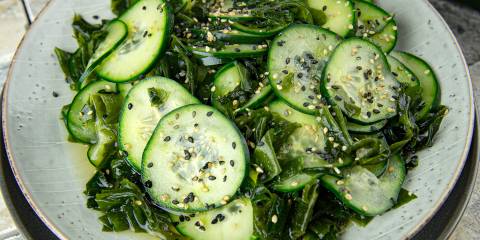 Cucumber Wakame Salad a plate of cucumber with oil, vinegar, wakame flakes, and sesame