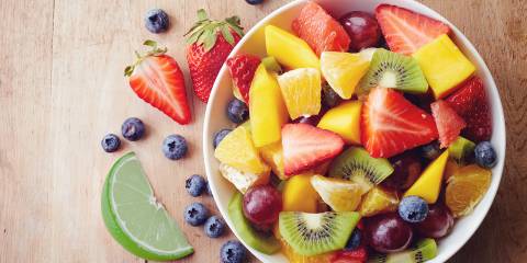 Fruit Salad with Honey-Lime Dressing a bowl of fruit salad and a sliced lime