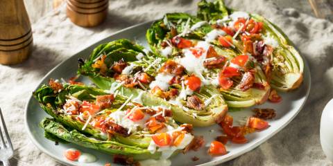 Grilled Romaine Romain lettuce with toppings on it.