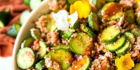 a bowl of tuna and cucumber with spicy sauce