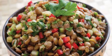 a bowl of lentils and veggies with garnish