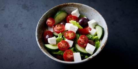 Mediterranean Salad a bowl of greek salad with cucumbers, olives, and cherry tomatoes