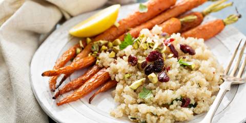 Quinoa Salad with Pistachios and Cranberries Quinoa salad with pistachios served on a white plate with roasted potatoes.