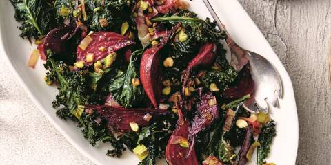 a plate of roasted vegetables with dressing