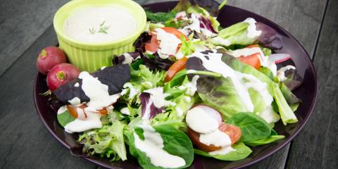 A bowl of salad drizzled with Tahini Dill dressing.