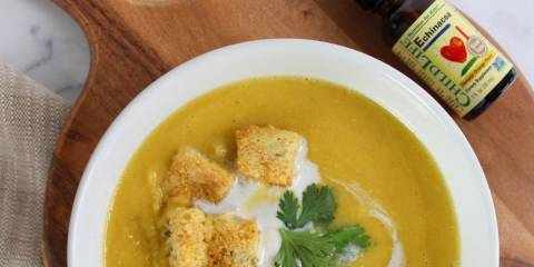 a bowl of butternut squash soup and a bottle of echinacea