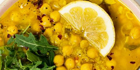 Life-Affirming Chickpea Soup a bowl of chickpea soup garnished with arugula and lemon