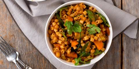 Spicy Ditalini and Chickpea Stew in a white bowl on a wooden table.