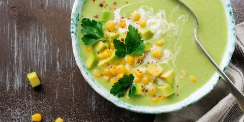 Thai Coconut Soup with Corn and Avocado a bowl of creamy green soup with corn, diced avocado, and spices