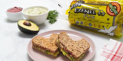 a sandwich with beets, avocado, and dill cheese spread
