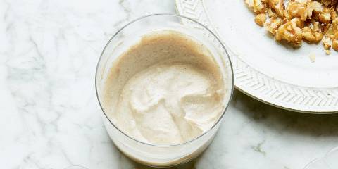 Cashew Sour Cream in a glass on a marble tabletop.