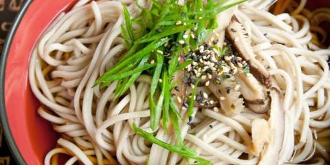 Soba Noodles in Dashi Broth a bowl of soba noodles garnished with sesame seeds and scallions