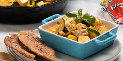 a dish of tofu curry served with pocket bread