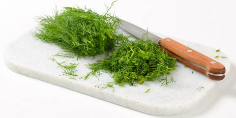 Sprigs of fresh dill on a cutting board