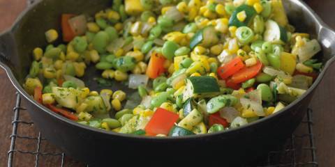 a skillet of sautéed corn and diced vegetables