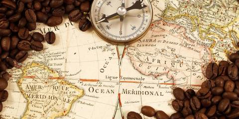 a historic map of South America and Africa, covered in coffee beans