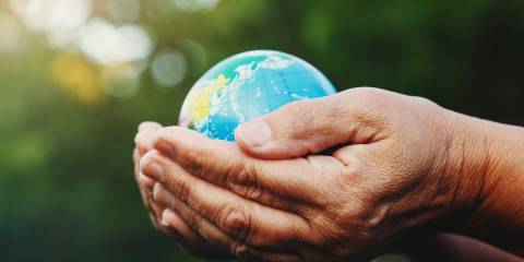 a senior woman cradling the world in her hands